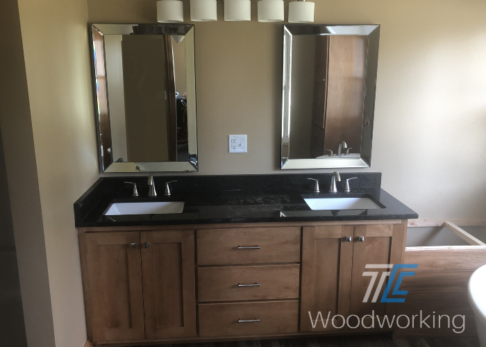 bathroom vanity, brown cabinets and drawers double sinks, granite countertop, side by side mirrors, overhead lighting