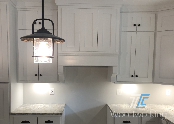 decorative overhead lighting, white wall mounted kitchen cabinets, granite counter 