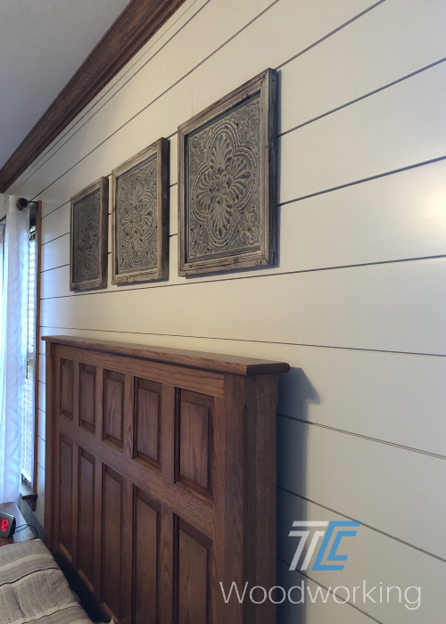 shiplapped wall, white planks, brown bed headboard, three over the bed decorative art